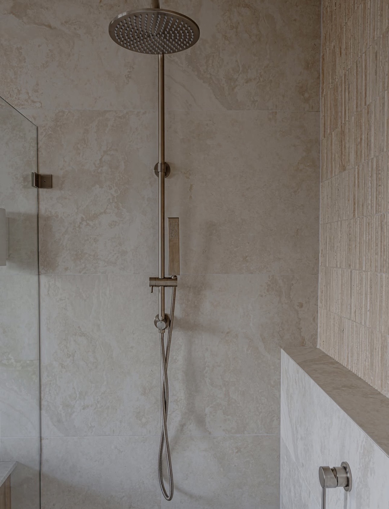 Feature shower wall with large format tiles and brushed fixtures